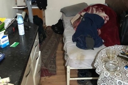 Bed in kitchen in dangerous conditions