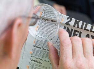 Man using magnifying glass to read